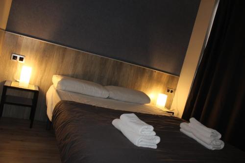 a hotel room with a bed with white towels on it at BCN Condal Hostal in Barcelona