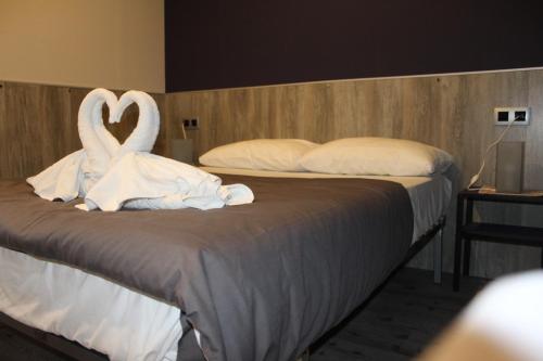 a bed with two swans made out of towels at BCN Condal Hostal in Barcelona