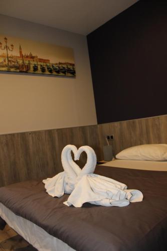 two swans making a heart on a bed at BCN Condal Hostal in Barcelona