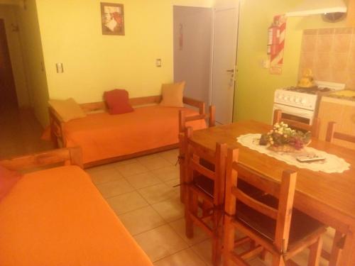 a kitchen and living room with a table and a couch at Apartamento Confortable Samai Huasi in Las Grutas