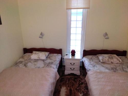 a room with two beds and a table with a window at Mustvee Creek Cottage in Mustvee