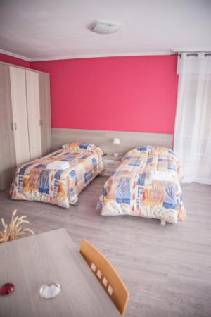 a bedroom with two beds and a table in it at Pensión Parque del Ebro in Logroño