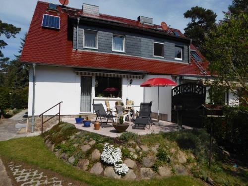 a white house with a red roof and a patio at Ferienhaus SUN Schein in Templin in Templin