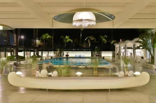 a hotel lobby with a large pool and a large ceiling at Hotel Cerere in Paestum