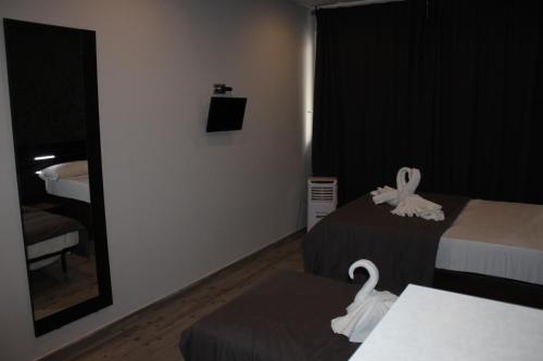 a hotel room with two beds with swans on them at BCN Condal Hostal in Barcelona