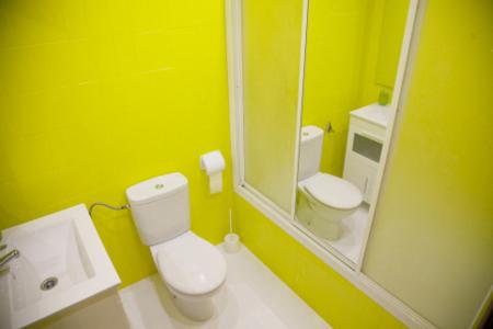 a yellow bathroom with a toilet and a sink at Pensión Parque del Ebro in Logroño