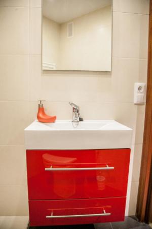 a bathroom with a red cabinet with a sink at Pensión Parque del Ebro in Logroño
