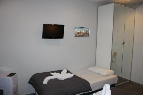 a bedroom with a bed and a flat screen tv at BCN Condal Hostal in Barcelona