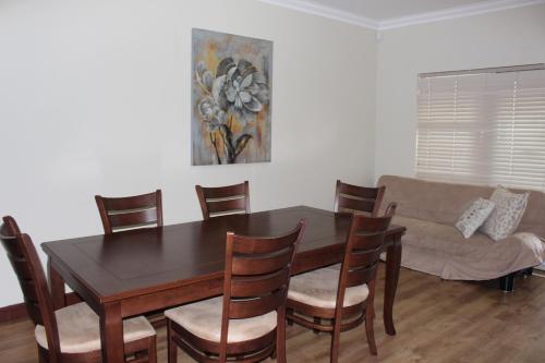 a dining room with a table and chairs and a couch at Vista Bonita Apartments in Mossel Bay