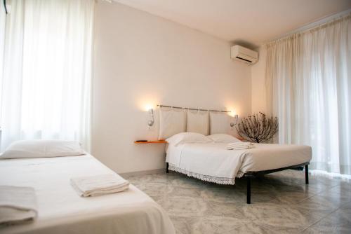 2 łóżka w pokoju z białymi ścianami i oknami w obiekcie Bed and Breakfast Sofia w mieście Pescara