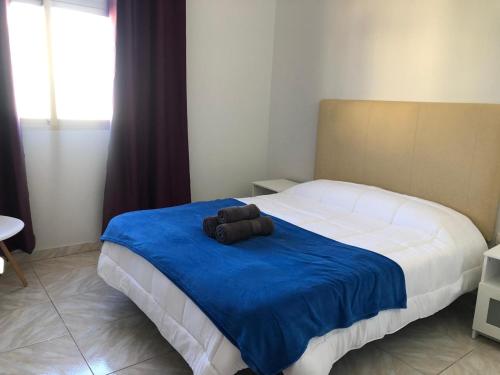a bedroom with a large bed with a blue blanket at FANTÁSTICO APTO. 6 pax, TABLERO 5, cerca PLAYA INGLÉS in El Tablero