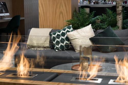 a living room with a couch with fires in the foreground at 9Hotel Paquis in Geneva