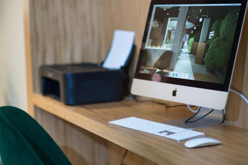 a computer monitor sitting on a desk with a printer at 9Hotel Paquis in Geneva