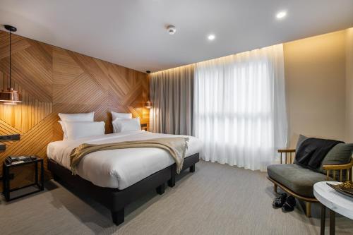 a hotel room with a bed and a chair at 9Hotel Paquis in Geneva