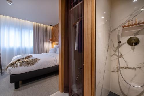 a hotel room with a shower and a bed at 9Hotel Paquis in Geneva