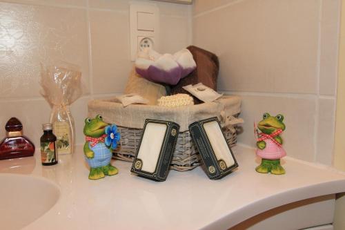 eine Badezimmertheke mit einem Waschbecken und zwei Froschfiguren in der Unterkunft Old Saxo in Ypern