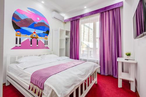 ein Schlafzimmer mit einem großen Bett und lila Vorhängen in der Unterkunft WHITE HOTEL & HOSTEL in Bischkek
