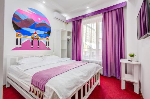 a bedroom with a large bed and purple curtains at WHITE HOTEL & HOSTEL in Bishkek