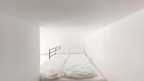 a bedroom with a bed in a white room at Aparthotel Tectum TectumApartments in Wrocław