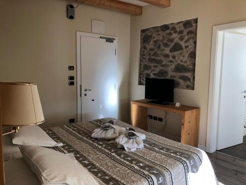 a bedroom with a bed with a lamp and a television at Hotel Savoia dal 1924 in San Martino di Castrozza