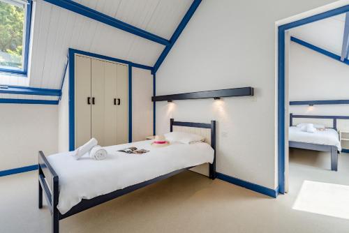Cette chambre comprend 2 lits et un miroir. dans l'établissement Azureva Kerjouanno, à Arzon