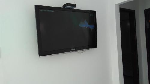 a flat screen tv hanging on a wall at Casa na praia de Aruana in Atalaia Velha