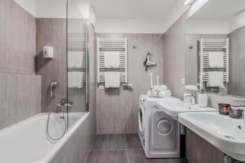 a bathroom with two sinks and a washing machine at Prague Luxury Apartments Parking by Michal&Friends in Prague