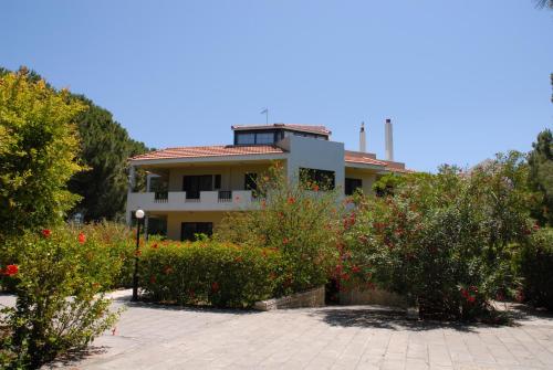 a house with a lot of flowers in front of it at Niki Hotel Apartments in Ialyssos