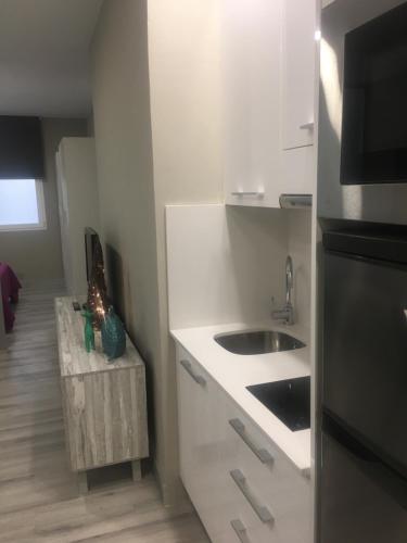 a small white kitchen with a sink and a counter at TC Lindamar in Las Palmas de Gran Canaria