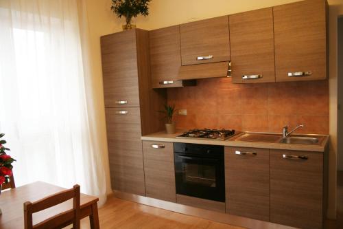 a kitchen with wooden cabinets and a sink and a stove at Villa dei Fiori in Luino