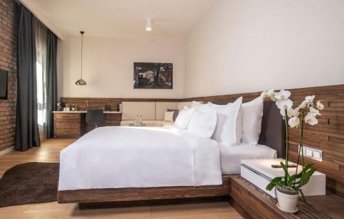 a bedroom with a large white bed and a desk at Radisson Collection Hotel, Old Mill Belgrade in Belgrade
