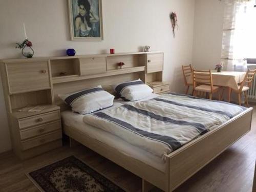 een slaapkamer met een bed, een dressoir en een tafel bij Pension Nama in Spiegelau