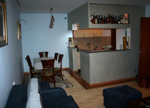 ein Wohnzimmer mit einem Sofa und einem Tisch sowie eine Küche in der Unterkunft Fenix Cvetni trg in Belgrad