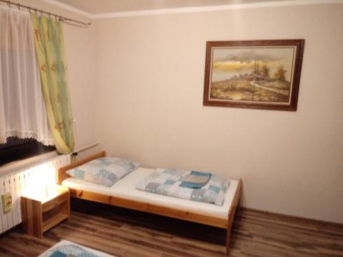 a bedroom with a bed and a painting on the wall at Gazdówka "Pod Pstrągiem" in Korbielów