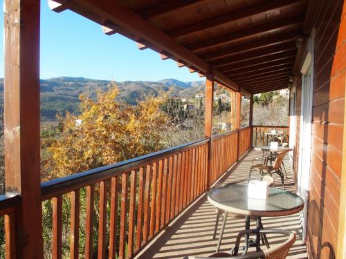 a balcony with tables and chairs and a view at Ktima Noosfera Wellness & Retreat Center in Nees Vrisoules