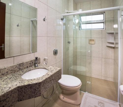 uma casa de banho com um WC, um lavatório e um chuveiro em Hotel Rosenbrock no Balneário Camboriú