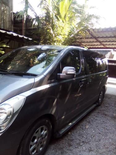a silver car parked in a driveway at Chom Chan Guesthouse & Hostel in Chiang Mai