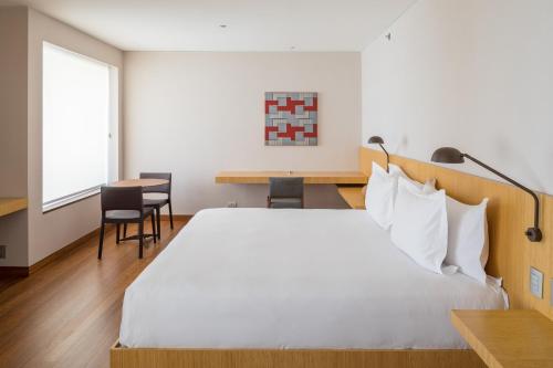 a bedroom with a large bed and a table and chairs at B Hotel Brasilia in Brasilia