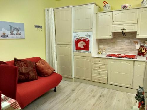 een woonkamer met een rode bank in een keuken bij Sweet Home in Castelletto sopra Ticino