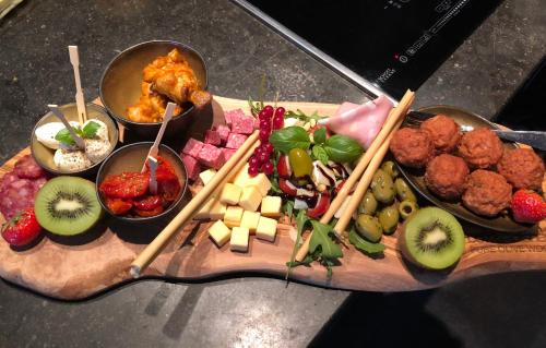 a tray of food with meatballs and fruit and vegetables at B&B Maison Beau in Zonhoven