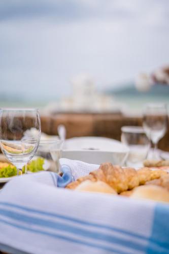 a table with a plate of food and a glass of wine at Royal Thai Villa Phuket - SHA Extra Plus in Rawai Beach