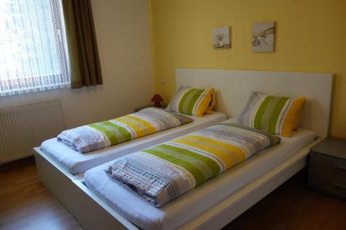 2 Betten mit Kissen auf einem Zimmer in der Unterkunft Appartements Kubisko in Keutschach am See
