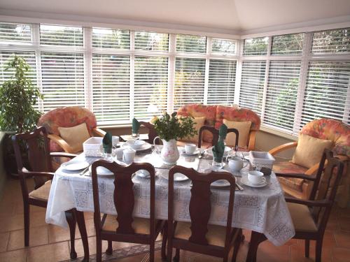 a dining room with a table and chairs and windows at Chez Sé in Drogheda
