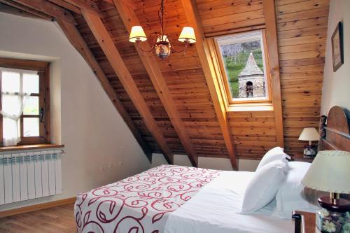 1 dormitorio con 1 cama en una habitación con techos de madera en Apartamentos Deth Camin Reiau, en Arties