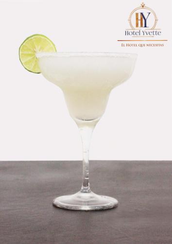una bebida en un vaso de martini con una cuña de limón en Hotel Yvette, en León