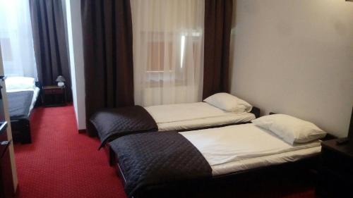 a hotel room with two beds and a couch at Hotel Graal Targowisko in Targowisko