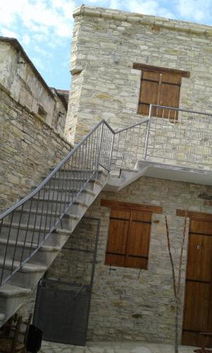 a staircase on the side of a building with wooden doors at Christiana's stone studios in Pano Lefkara