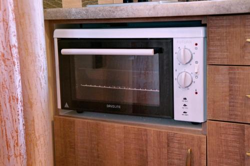 a microwave oven sitting on top of a wooden cabinet at Ktima Kiourelioti in Skála Sykaminéas