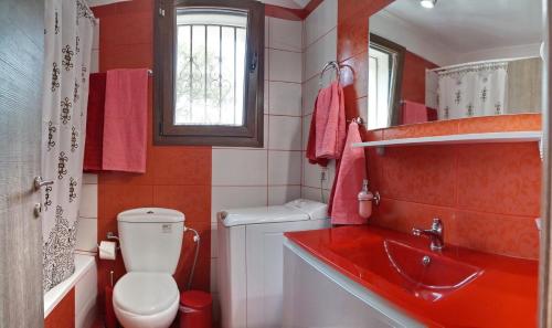 a red bathroom with a toilet and a sink at Ktima Kiourelioti in Skála Sykaminéas