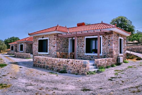 a small stone house with a red roof at Ktima Kiourelioti in Skála Sykaminéas